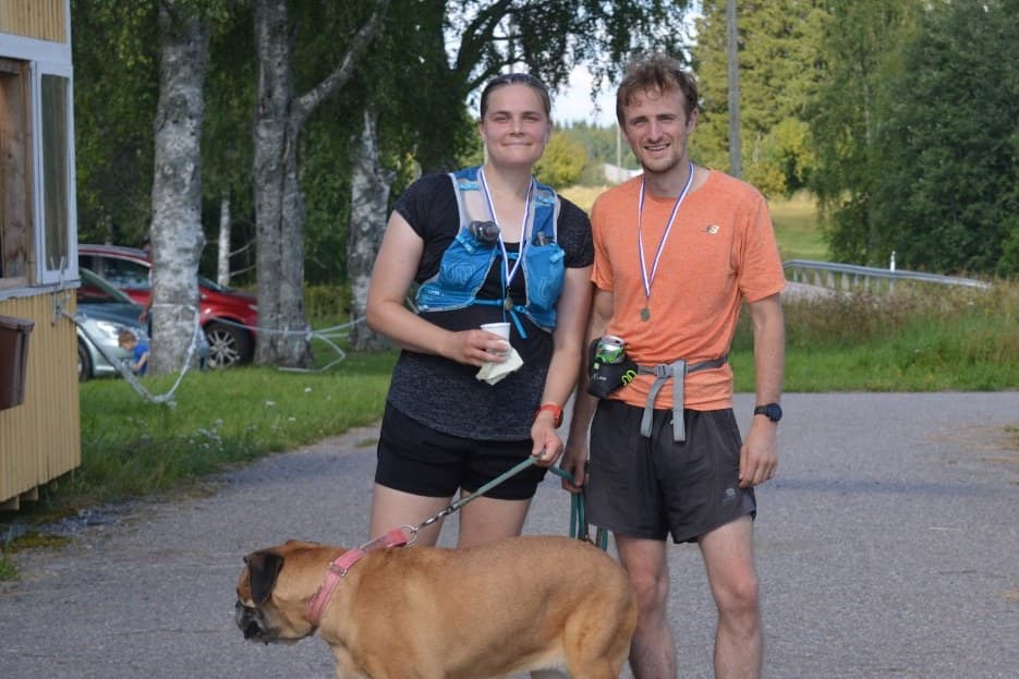 Curtis and Iina with Moira the Bullmastiff at a trail race finish line in Finland